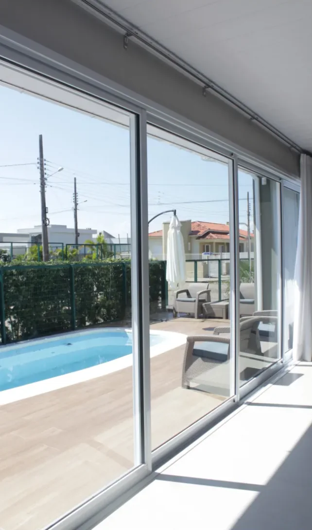 Portas de correr da linha Gold 32 abertas para a piscina